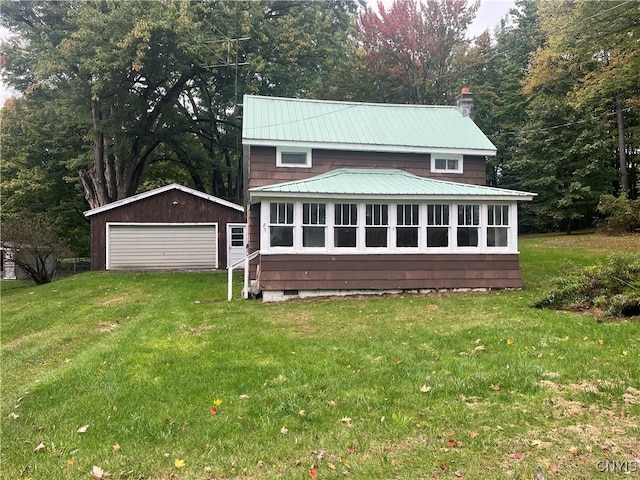 back of property with a yard, an outbuilding, and a garage