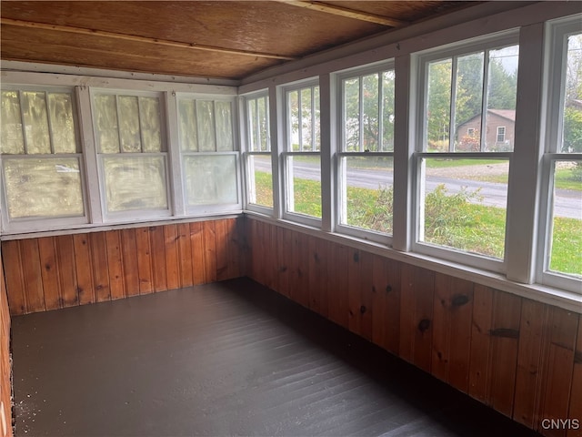 unfurnished sunroom featuring a healthy amount of sunlight and wooden ceiling