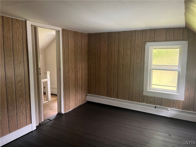 unfurnished room with wooden walls, dark wood-type flooring, vaulted ceiling, and baseboard heating