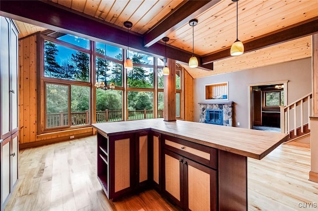 interior space with a fireplace, beam ceiling, and wooden ceiling