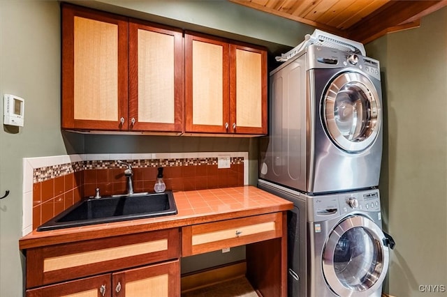 washroom featuring sink, cabinets, and stacked washer / drying machine