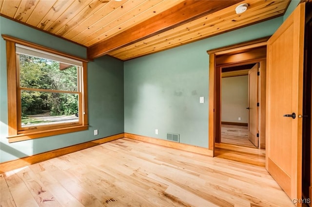 unfurnished room with light wood-type flooring and wooden ceiling