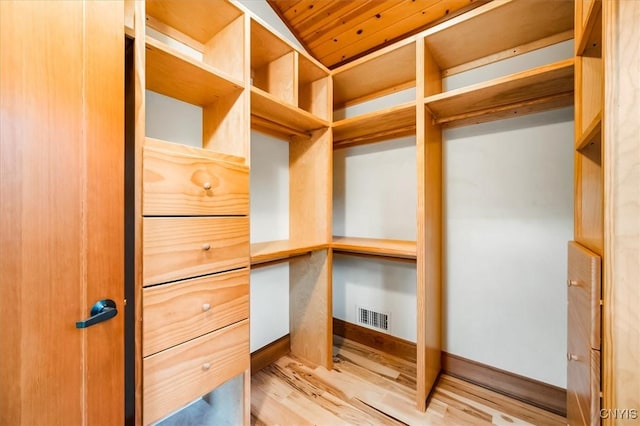 spacious closet with vaulted ceiling and light hardwood / wood-style flooring