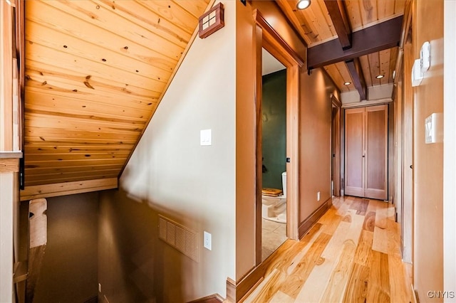 hall with light wood-type flooring, vaulted ceiling with beams, and wooden ceiling