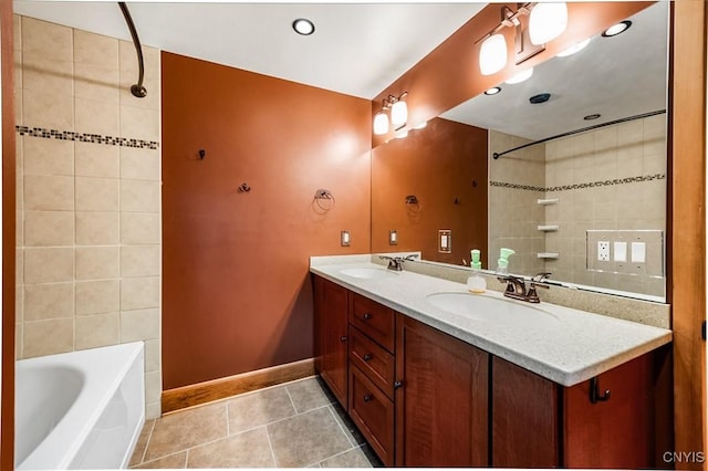 bathroom with tile patterned flooring, vanity, and tiled shower / bath