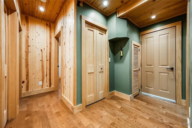 mudroom with wood ceiling, wood walls, and light hardwood / wood-style floors