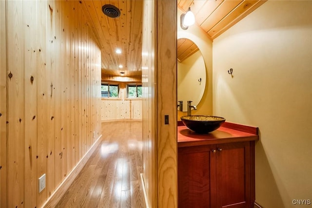 bathroom featuring hardwood / wood-style flooring, vanity, and wood ceiling