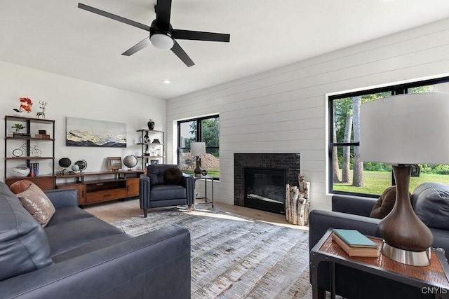 LOT64 Chillingham Way, Lysander, NY 13027 - living area featuring ceiling fan, wood finished floors, a glass covered fireplace, wood walls, and recessed lighting