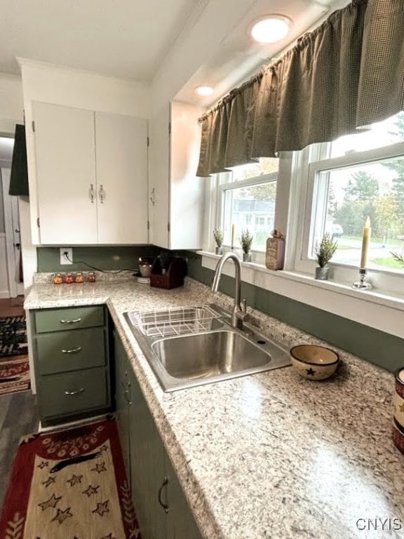 kitchen with dark hardwood / wood-style floors, sink, and white cabinetry