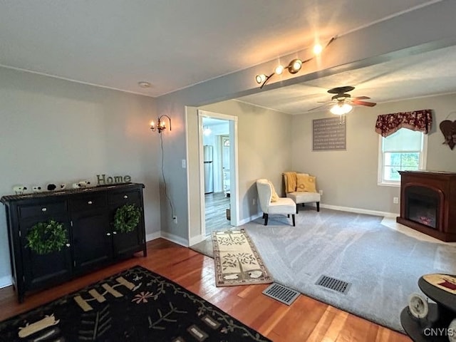 living area featuring hardwood / wood-style flooring and ceiling fan