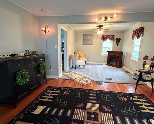 living room with ceiling fan, a fireplace, and hardwood / wood-style floors