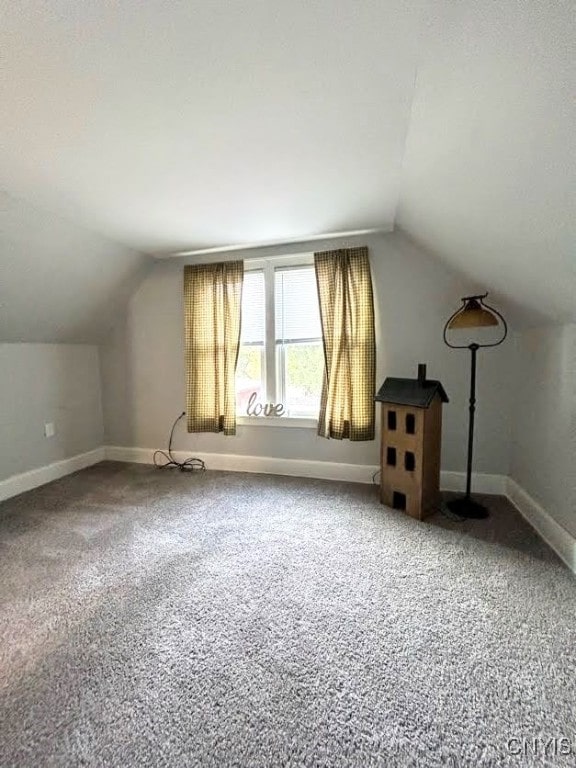 bonus room with vaulted ceiling and carpet