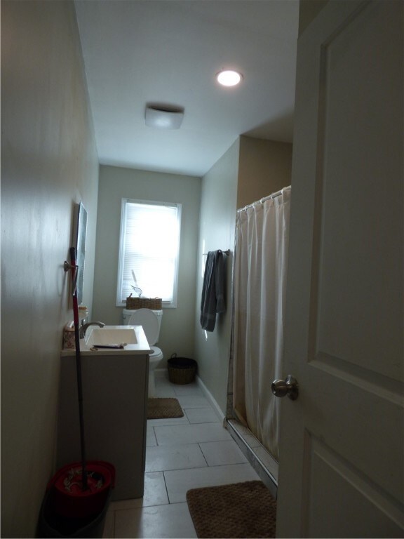 bathroom featuring vanity, tile patterned flooring, toilet, and a shower with shower curtain