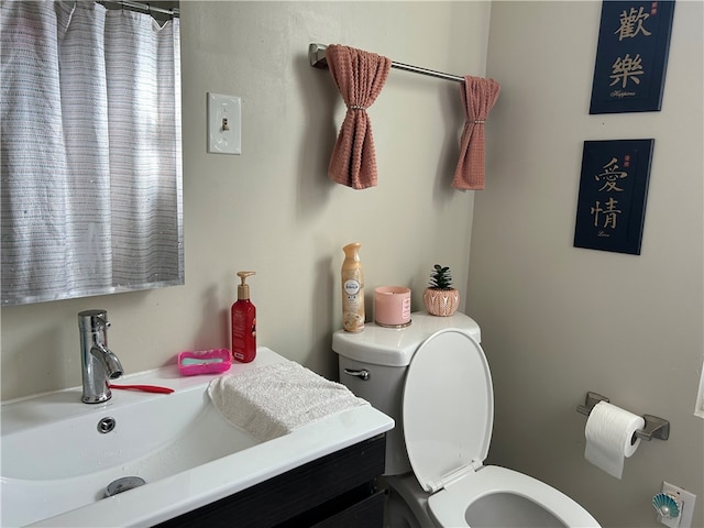 bathroom featuring vanity, walk in shower, and toilet