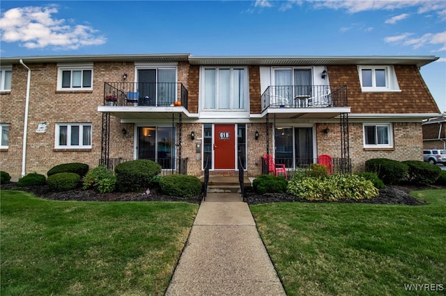 townhome / multi-family property featuring a front yard and a balcony