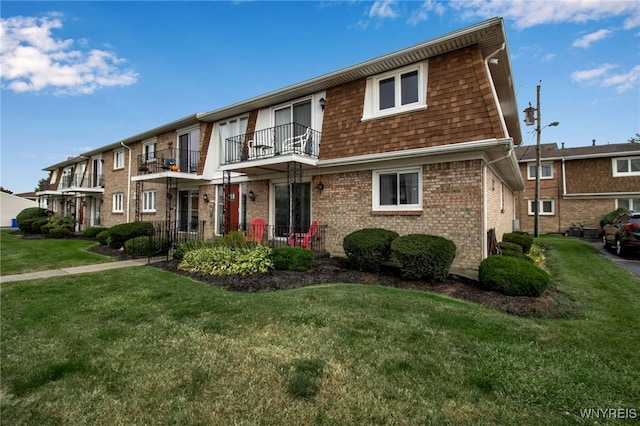 view of front of house with a balcony and a front lawn