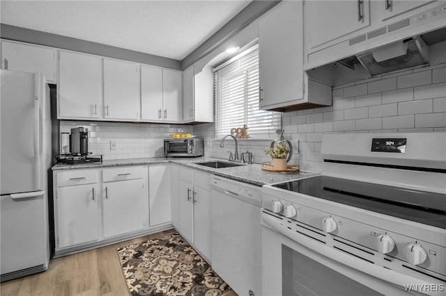 kitchen featuring light wood-type flooring, white cabinets, white appliances, sink, and backsplash