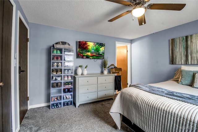 bedroom with ceiling fan, dark carpet, and a textured ceiling