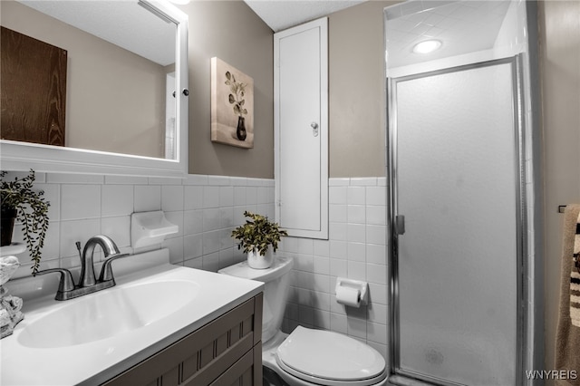 bathroom featuring an enclosed shower, tile walls, vanity, and toilet