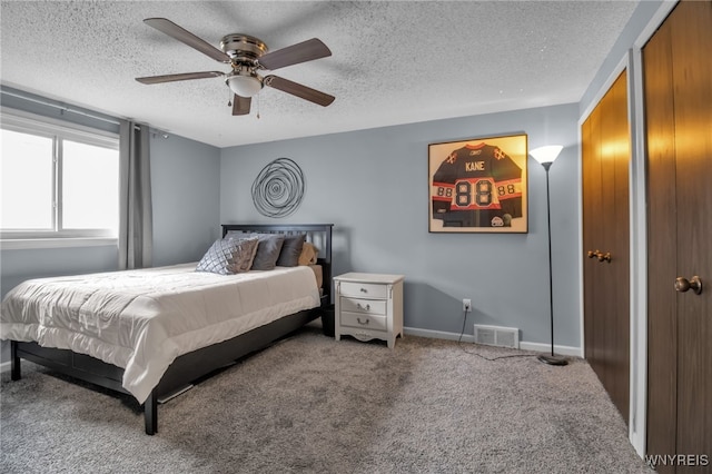 carpeted bedroom featuring a textured ceiling and ceiling fan