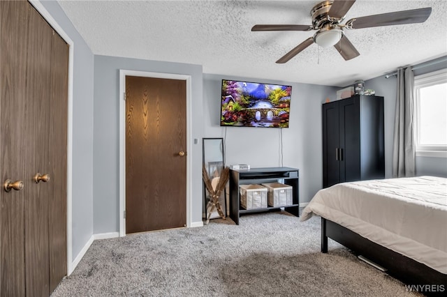 carpeted bedroom with ceiling fan, a closet, and a textured ceiling