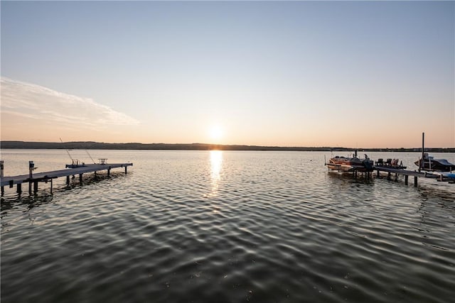 dock area with boat lift and a water view