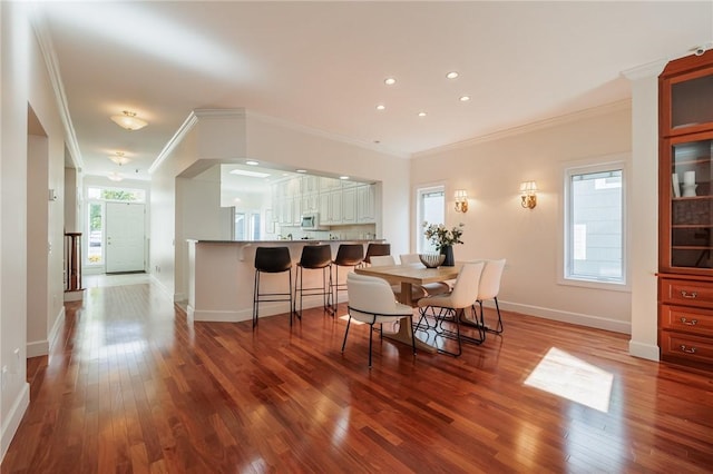 dining room featuring crown molding, recessed lighting, wood finished floors, and baseboards