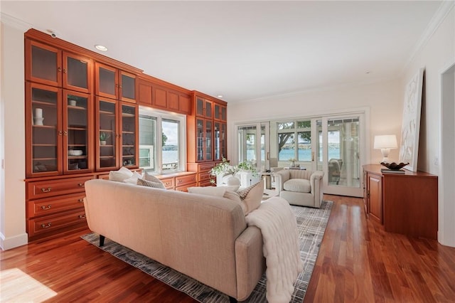 living area featuring a wealth of natural light, crown molding, and wood finished floors