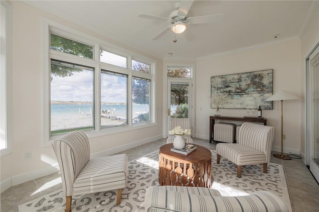 sitting room featuring ceiling fan, light tile patterned floors, baseboards, and ornamental molding