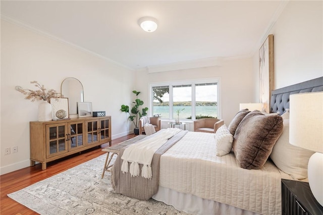 bedroom featuring crown molding, wood finished floors, and baseboards