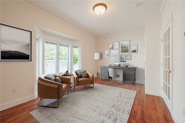 living area with crown molding, wood finished floors, and baseboards