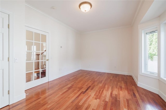 spare room featuring baseboards, light wood-style floors, and ornamental molding