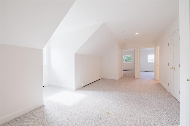 bonus room with light colored carpet, lofted ceiling, baseboard heating, and baseboards