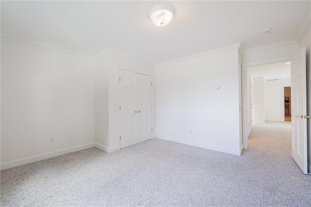 empty room with light colored carpet, baseboards, and ornamental molding