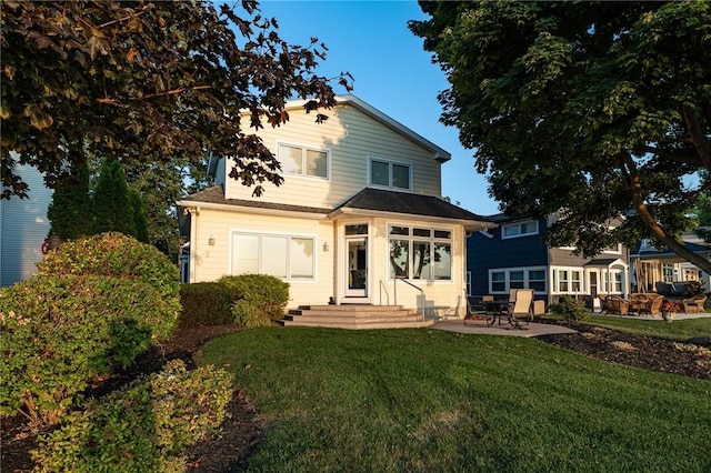 view of front facade featuring entry steps, a front yard, and a patio