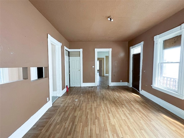 corridor featuring light hardwood / wood-style floors and a textured ceiling