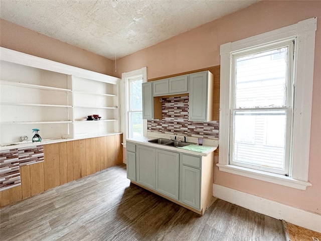 kitchen featuring wood-type flooring, a textured ceiling, sink, and decorative backsplash