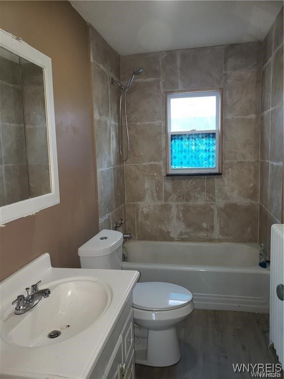 full bathroom with tiled shower / bath, vanity, and toilet