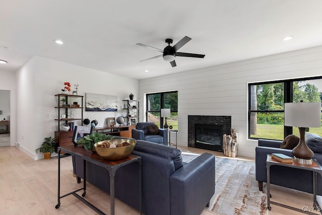 living room featuring light wood-type flooring, a healthy amount of sunlight, and ceiling fan