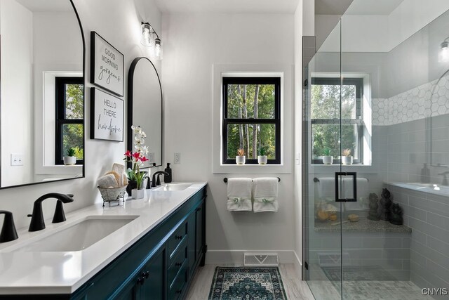 bathroom with hardwood / wood-style floors, vanity, and a shower with shower door