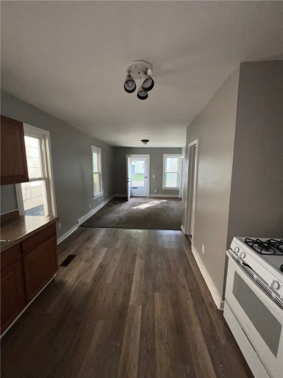 interior space featuring white gas range, a healthy amount of sunlight, and dark hardwood / wood-style floors