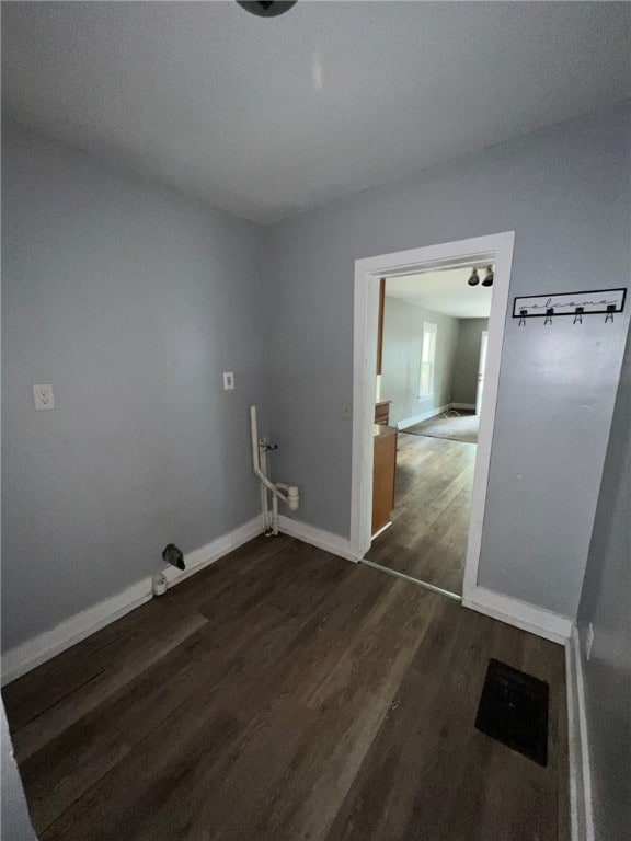 laundry area with dark wood-type flooring