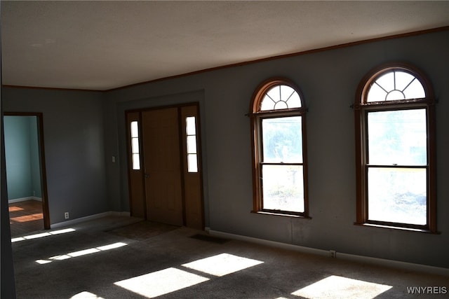 unfurnished room featuring dark carpet, a textured ceiling, and crown molding