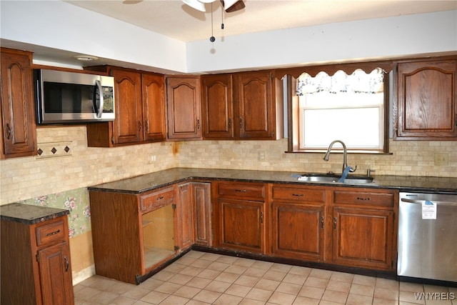 kitchen with decorative backsplash, dark stone countertops, appliances with stainless steel finishes, and sink