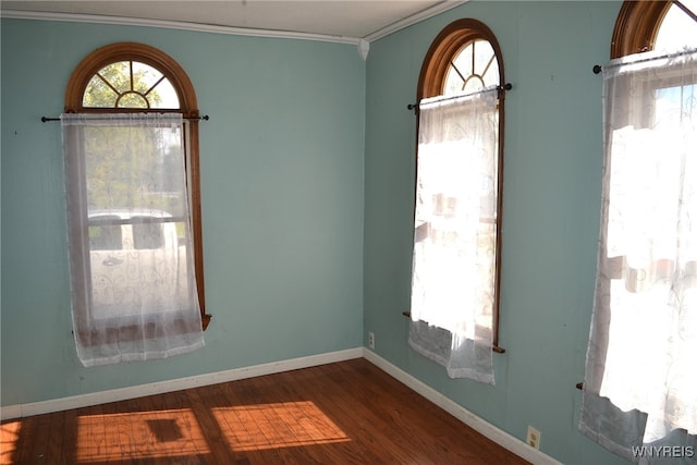 empty room featuring crown molding and dark hardwood / wood-style floors