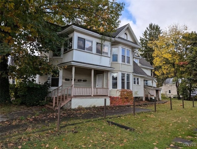 victorian home with a porch and a front yard