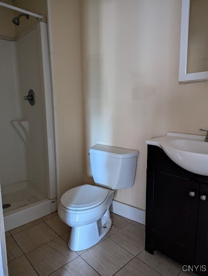 bathroom featuring walk in shower, vanity, tile patterned flooring, and toilet