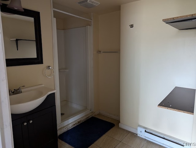 bathroom featuring walk in shower, vanity, tile patterned flooring, and a baseboard heating unit