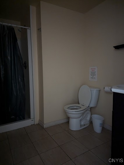 bathroom with tile patterned flooring, curtained shower, vanity, and toilet