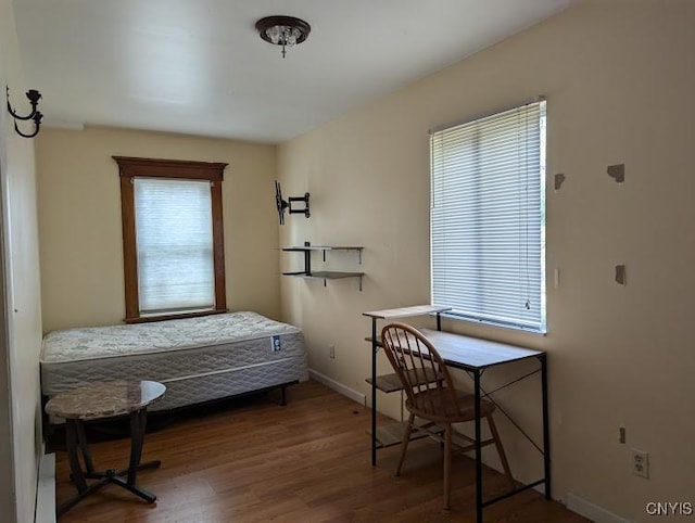 bedroom featuring baseboards and wood finished floors